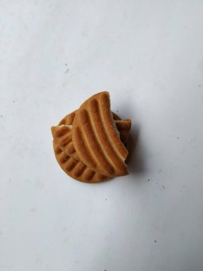 Yuvarlak Kahverengi Bisküvi ve Kesik Kurabiye 'nin yakın çekimi beyaz arka planda izole edildi. Bisküvinin üzerindeki eğri şekil.