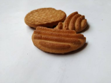 Yuvarlak Kahverengi Bisküvi ve Kesik Kurabiye 'nin yakın çekimi beyaz arka planda izole edildi. Bisküvinin üzerindeki eğri şekil.