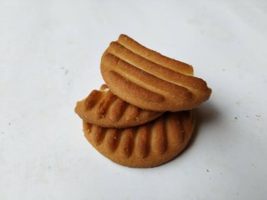 Yuvarlak Kahverengi Bisküvi ve Kesik Kurabiye 'nin yakın çekimi beyaz arka planda izole edildi. Bisküvinin üzerindeki eğri şekil.