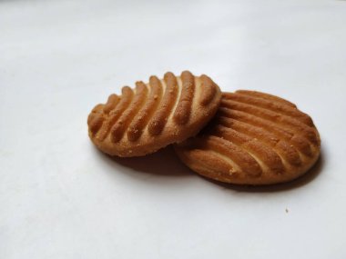 Yuvarlak Kahverengi Bisküvi ve Kesik Kurabiye 'nin yakın çekimi beyaz arka planda izole edildi. Bisküvinin üzerindeki eğri şekil.