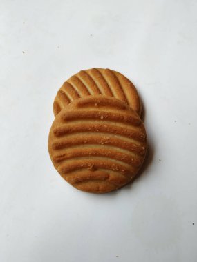 Yuvarlak Kahverengi Bisküvi ve Kesik Kurabiye 'nin yakın çekimi beyaz arka planda izole edildi. Bisküvinin üzerindeki eğri şekil.