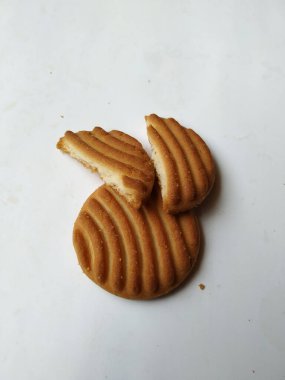 Yuvarlak Kahverengi Bisküvi ve Kesik Kurabiye 'nin yakın çekimi beyaz arka planda izole edildi. Bisküvinin üzerindeki eğri şekil.