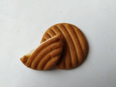 Yuvarlak Kahverengi Bisküvi ve Kesik Kurabiye 'nin yakın çekimi beyaz arka planda izole edildi. Bisküvinin üzerindeki eğri şekil.