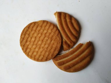 Yuvarlak Kahverengi Bisküvi ve Kesik Kurabiye 'nin yakın çekimi beyaz arka planda izole edildi. Bisküvinin üzerindeki eğri şekil.