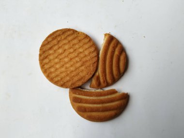 Yuvarlak Kahverengi Bisküvi ve Kesik Kurabiye 'nin yakın çekimi beyaz arka planda izole edildi. Bisküvinin üzerindeki eğri şekil.