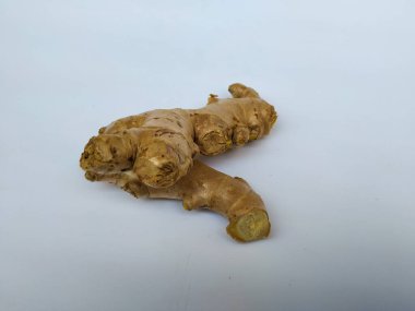 Beyaz arkaplanda taze zencefil kökü veya rhizomu yakın plan