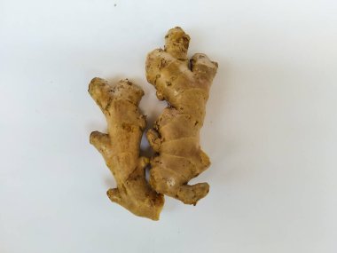 Beyaz arkaplanda taze zencefil kökü veya rhizomu yakın plan