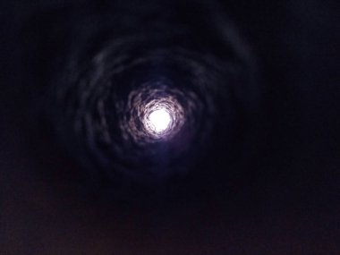 Yeraltında güzel bir delik ve siyah bir arka planda ışık sıçraması