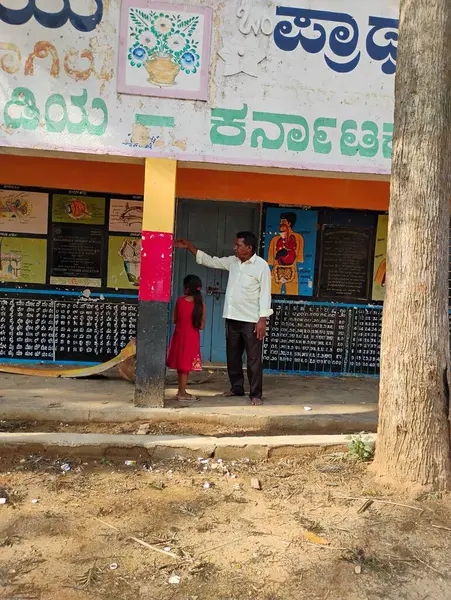 Mandya, Karnataka, Hindistan-14 Mayıs 2025: Büyükbabasını ve torununu Kadilavagilu Köyü 'nde gösteren güzel devlet okulu binasının kapatılması.