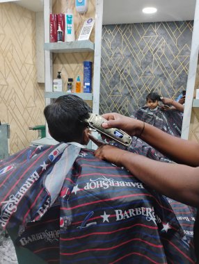 Bangalore, Karnataka, Hindistan-05 Nisan 2025: Bir dükkanda Hintli Erkek Bebek saç kesimi ve stili.
