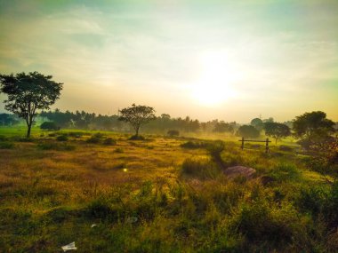 Güzel manzaralı tarım alanı, demiryolu istasyonu ve gündoğumu gökyüzü arka planına yakın..