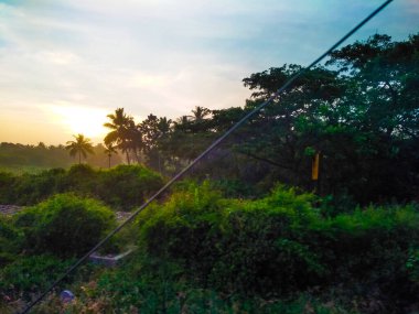Güzel manzaralı tarım alanı, demiryolu istasyonu ve gündoğumu gökyüzü arka planına yakın..