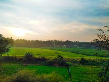 Güzel manzaralı tarım alanı, demiryolu istasyonu ve gündoğumu gökyüzü arka planına yakın..