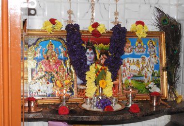 Bangalore, Karnataka, Hindistan-12 Ekim 2020: Puja odasının tanrı fotoğrafı çerçeveli güzel çiçek dekorasyonunun kapatılması.