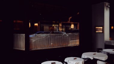 Londra, İngiltere - 25 Mart 2025: Mayfair 'de bir restoran olan Bay Nice' in penceresinden geçen arabaların yansımaları..