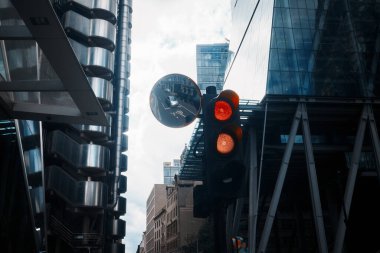 Londra, İngiltere - 28 Eylül 2024: Kırmızı trafik ışığı ve dışbükey ayna Londra şehrinde cam ve çelik binalarla çevrili bir Londra caddesini yansıtıyor.
