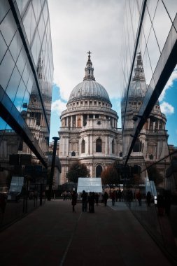 Londra, İngiltere - 28 Eylül 2024: Ağaçlar, taş cepheler ve modern binalarla çevrili St. Pauls Katedrali 'nin manzaraları, tarihi ve gelişmekte olan Londra' nın ahengini yansıtıyor.