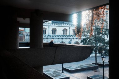 Londra, İngiltere - 28 Eylül 2024: Cripplegate 'siz Tarihi St. Giles Kilisesi Barbican Malikanesi' nin beton mimarisi tarafından yumuşak sabah ışığında çerçevelenmiştir.