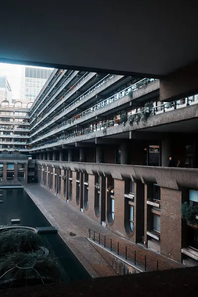 Londra, İngiltere - 28 Eylül 2024: Barbican Estate, Londra 'da bulunan Gilbert House' un Brutalist yerleşim balkonları ve kanal geçidi, beton ve su özellikleri ile çevrili.