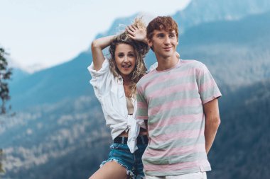 İki arkadaş ya da çift yol boyunca bisiklet sürüyor. Spor ve aktif yaşam günbatımı konsepti. Çift bisiklet sürmeyi öğreniyor, birlikte eğleniyor, şehrin yakınındaki dağlarda seyahat ediyor.