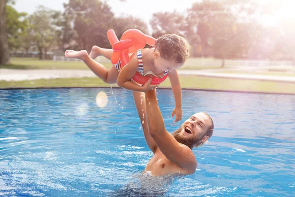 Stock image Dad holding child in his arms in the pool