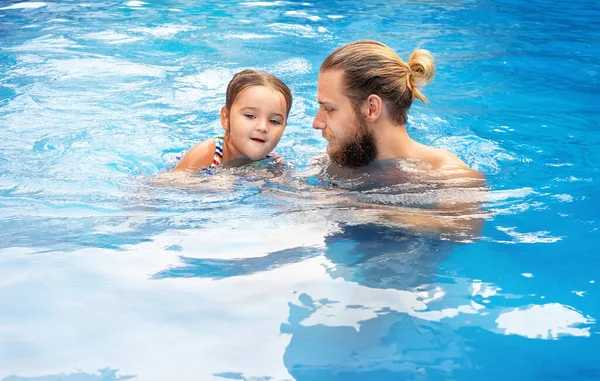 Havuzda yüzen bir adam ve kız.