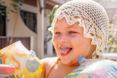 Uzun kollu neşeli bir çocuğun portresi tatilde yan tarafa bakıyor.