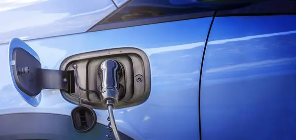 Stock image Blue electric car with charging plug close-up