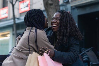 Mutlu Afrikalı arkadaşlar şehirdeki alışveriş çılgınlığından sonra birbirlerine sarılıyorlar.