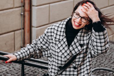beautiful brunette fixes her hair with her hand in the strong wind