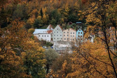 Dağ yamacındaki eski evlerin parlak bir sonbaharda bir ağaç dalları çerçevesinden görünüşü