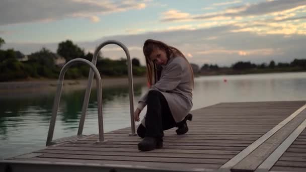 Seksi Esmer Kız Kameraya Bakar Gölün Kenarında Oturur Günbatımı Saatinde — Stok video