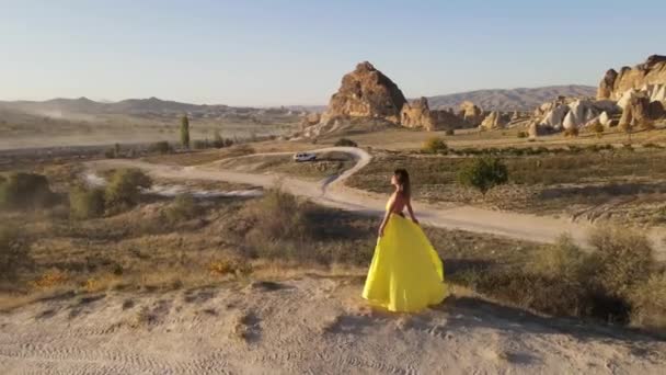 Panoramiczny Dron Ogląda Nagranie Dziewczyny Długiej Żółtej Sukience Ogonem Górach — Wideo stockowe