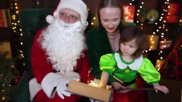 Mariupol ウクライナ 2021 幸せな母親は笑って 写真セッションで娘とサンタクロースと座って クリスマスを飾る近く 高品質のフルHd映像 — ストック動画