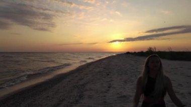 Slowmotion drone footage of Panoramic view of girl meditation on beach at sunset time. Aerial drone footage. High quality FullHD footage