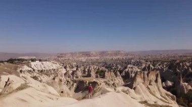 Türkiye, Kapadokya, 10.08.2021: Kapadokya kayaları ve insansız hava aracı görüntüleriyle güneş gözlüğü takan bir adamın insansız hava aracı görüntüleri. Yüksek kalite FullHD insansız hava aracı görüntüleri