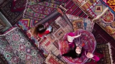 Two girls spinning on national carpets of Turkey in Cappadocia, Aerial view, Drone footage. High quality FullHD footage