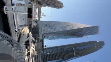 Vertical video of Dubai buildings, marina and boats, modern place, day time. High quality FullHD footage
