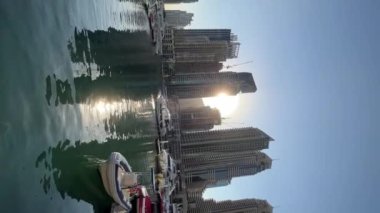 Dubai Marina with boats, bridges and tall buildings, sunset time, vertical video. High quality FullHD footage