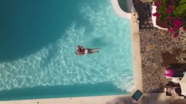 Top view of woman is swimming in pool hotel, summer time, Oludeniz, drone footage. High quality FullHD footage