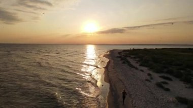 Girl run on the beach at sunset time, drone footage, fitness. High quality FullHD footage