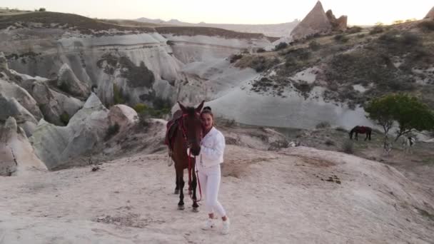 Dziewczyna Białymi Ubraniami Koniem Kapadocji Materiał Panoramiczny Zachodu Słońca Skały — Wideo stockowe