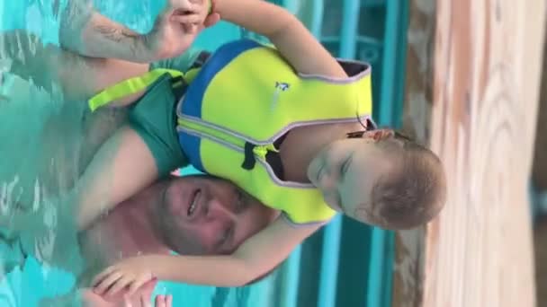 Can Yeleği Giyen Küçük Çocuk Babasıyla Yüzüyor Dubai Havuzunda Dinleniyor — Stok video
