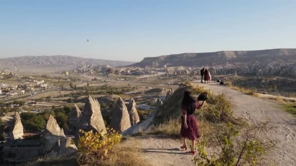 Kapadokya Daki Vadilerde Kayalıklarda Kayalar Üzerinde Şapkalı Kırmızı Elbiseli Genç — Stok video