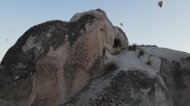 Kapadokya kayaları ve sıcak hava balonları gün batımına bakıyor. Yüksek kaliteli FullHD görüntüler