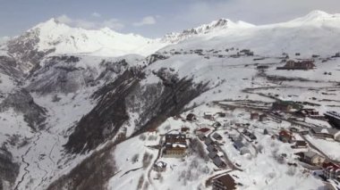 Kış mevsiminde Gürcistan 'daki kar dağlarının, dağdaki köyün havadan görünüşü, seyahat videoları. Yüksek kalite 4k görüntü