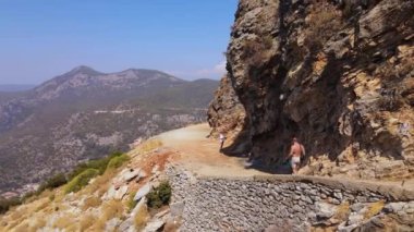 Aerial panoramic view of man walking on mountain, Oludeniz beach view. High quality 4k footage