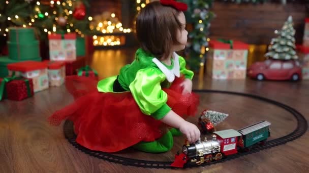 Dziewczynka Bawiąca Się Kolorowym Pociągiem Pokoju Urządzonym Boże Narodzenie Materiał — Wideo stockowe