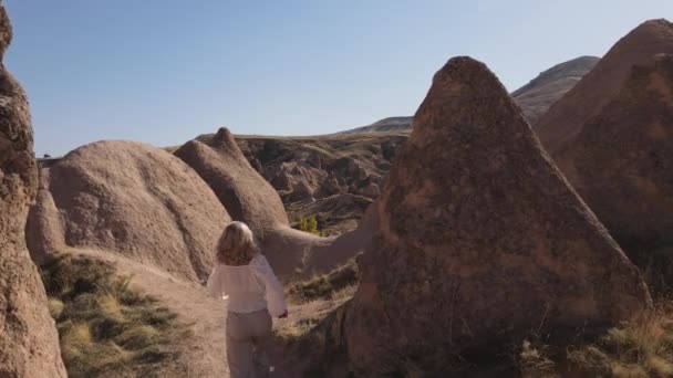 Погляд Щасливу Дівчину Біжить Скелях Долини Каппадокії Високоякісні Кадри Твердим — стокове відео