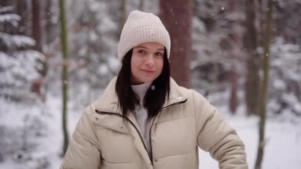 穿着夹克 头戴冬帽的可爱姑娘 望着镜头和微笑 美丽的背景 奥地利森林 高质量的4K镜头 — 图库视频影像